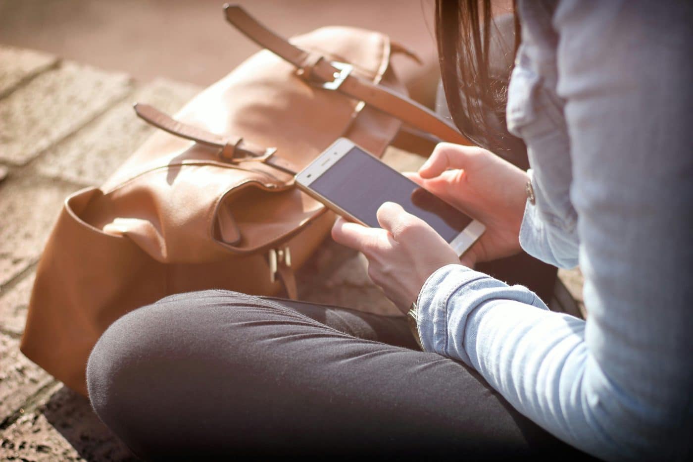 A person sits and looks at their phone