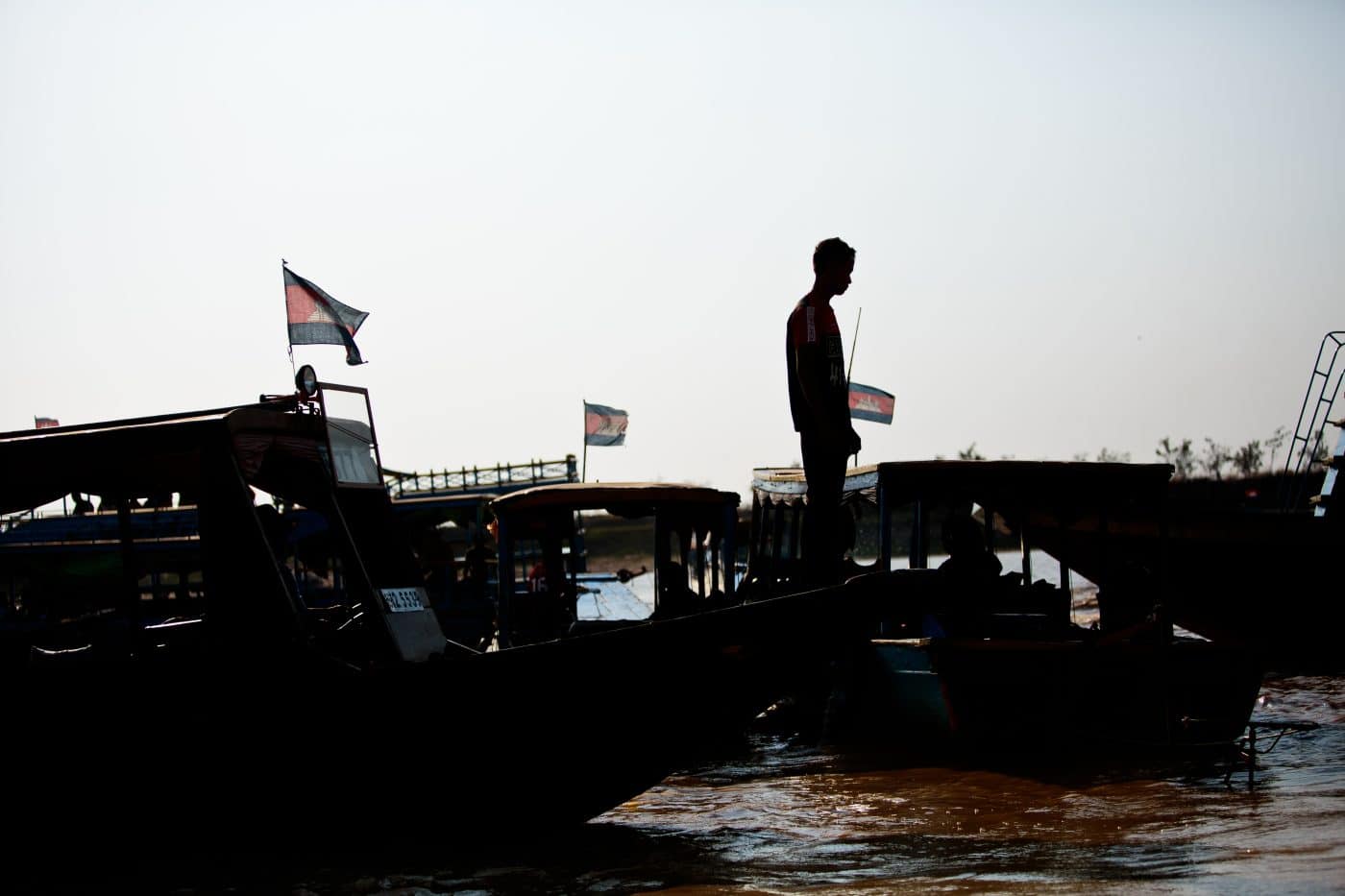 A fisherman is silhouetted on his boat on Tonle Sap Lake